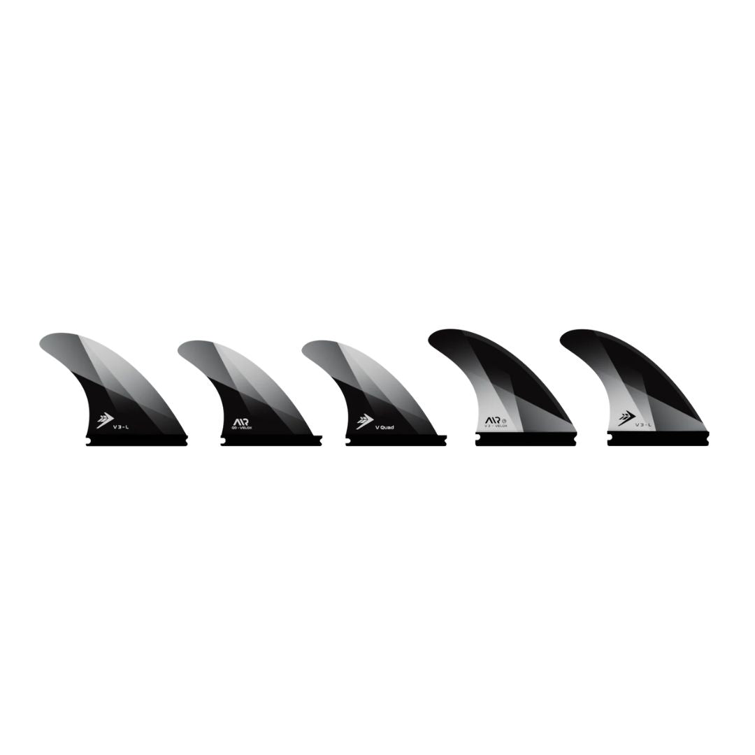 Detalle de las 5 quillas Firewire Velox talla Medium en acabado negro con acento blanco, mostrando el degradado de color en la punta de cada unidad.