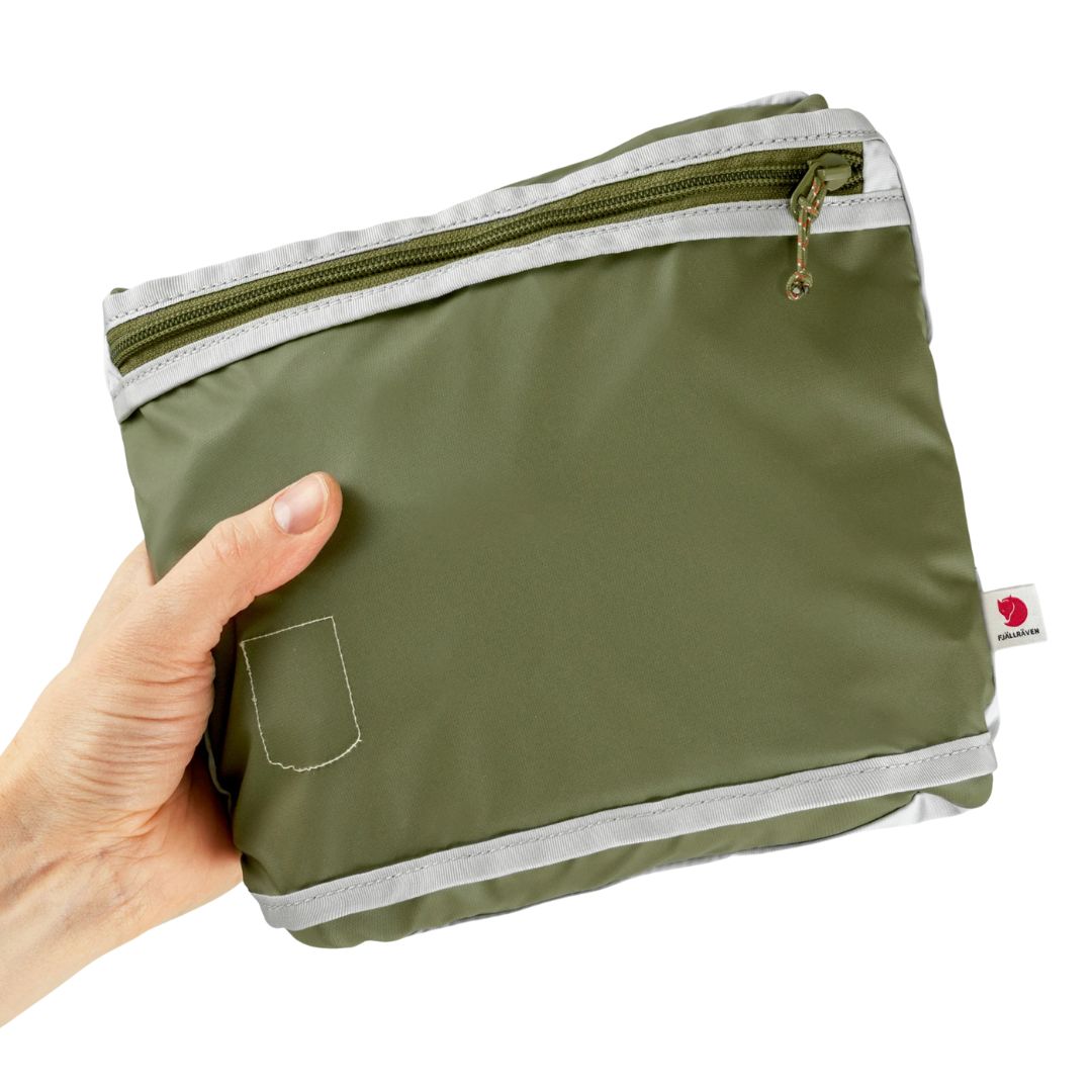 Mochila Fjällräven High Coast Totepack doblada y comprimida en su propio bolsillo interior
