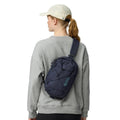 Fjällräven Skule Sling 6 azul marino vista trasera en uso, bandolera cruzada ligera con correa acolchada ajustable.