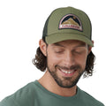Hombre con gorra Fjällräven Badge Långtradarkeps mirando hacia abajo mostrando ajuste y estructura ligera.