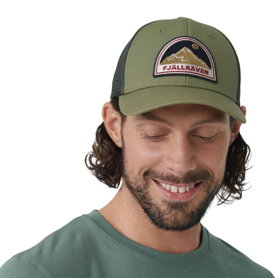 Hombre con gorra Fjällräven Badge Långtradarkeps mirando hacia abajo mostrando ajuste y estructura ligera.