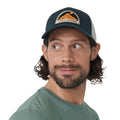 Hombre con gorra Fjällräven Badge Långtradarkeps vista frontal con parche bordado y diseño trucker.