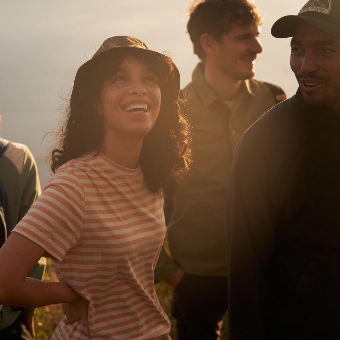 Grupo de personas en actividad outdoor al atardecer usando gorra Fjällräven Badge Långtradarkeps estilo trucker.