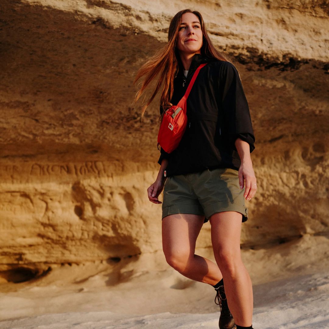 Modelo en ruta con la riñonera Fjällräven High Coast Hip Pack llevada en bandolera, ideal para senderismo y viaje.