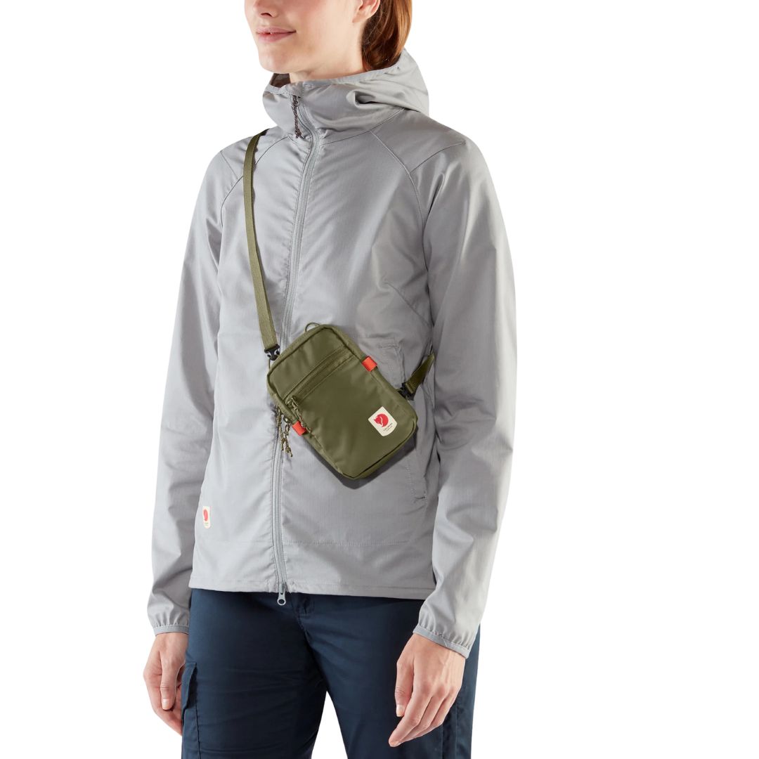 Persona usando el bolso Fjällräven High Coast Pocket cruzado sobre el pecho, ideal para actividades al aire libre.