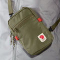 Vista frontal del bolso Fjällräven High Coast Pocket en uso cruzado, mostrando el diseño compacto y funcional.