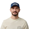 Hombre con gorra Fjällräven Långtradarkeps vista frontal mostrando diseño trucker con logo y ajuste cómodo.