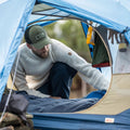 Hombre usando gorra Fjällräven Långtradarkeps dentro de una tienda de campaña en actividad outdoor.