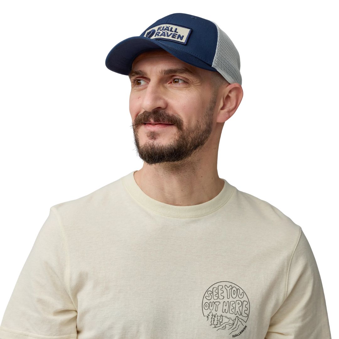 Hombre con gorra Fjällräven Långtradarkeps vista frontal con diseño trucker y paneles de malla.
