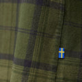 Detalle de tejido de la camisa Fjällräven Övik Twill Shirt M con etiqueta de la bandera sueca.