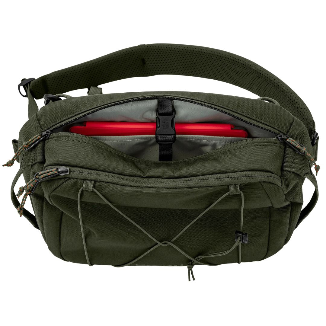 Interior de la Fjällräven Skule Sling 6 Deep Forest mostrando compartimento principal con funda acolchada para tablet de hasta 10 pulgadas y bolsillo frontal con cremallera.