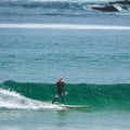 Surfista surfeando una ola con la tabla mini long Flysurf Cold Hawaii 8.0 en condiciones de mar limpio.