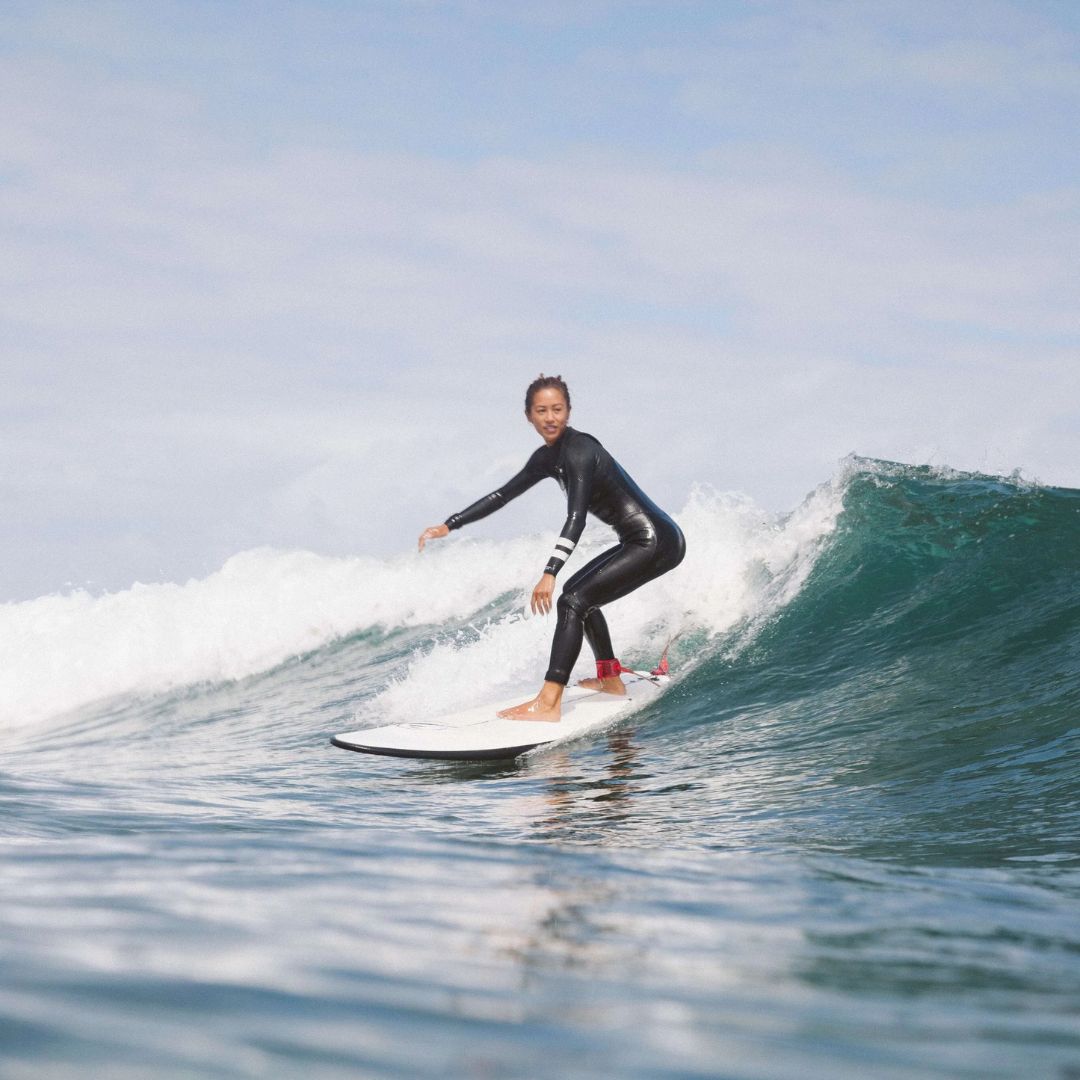 Surfista cabalgando una ola con la tabla evolutiva Flysurf The Traveller 6.6 blanca, diseñada para progresar de principiante a intermedio.