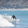 Surfista cabalgando con la tabla evolutiva Flysurf The Traveller 6.6 blanca en una ola abierta.