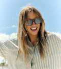 Mujer sonriendo con gafas de sol Warmouth Eyewear Cowboy Cool color carey, estilo vintage con lentes azul claro