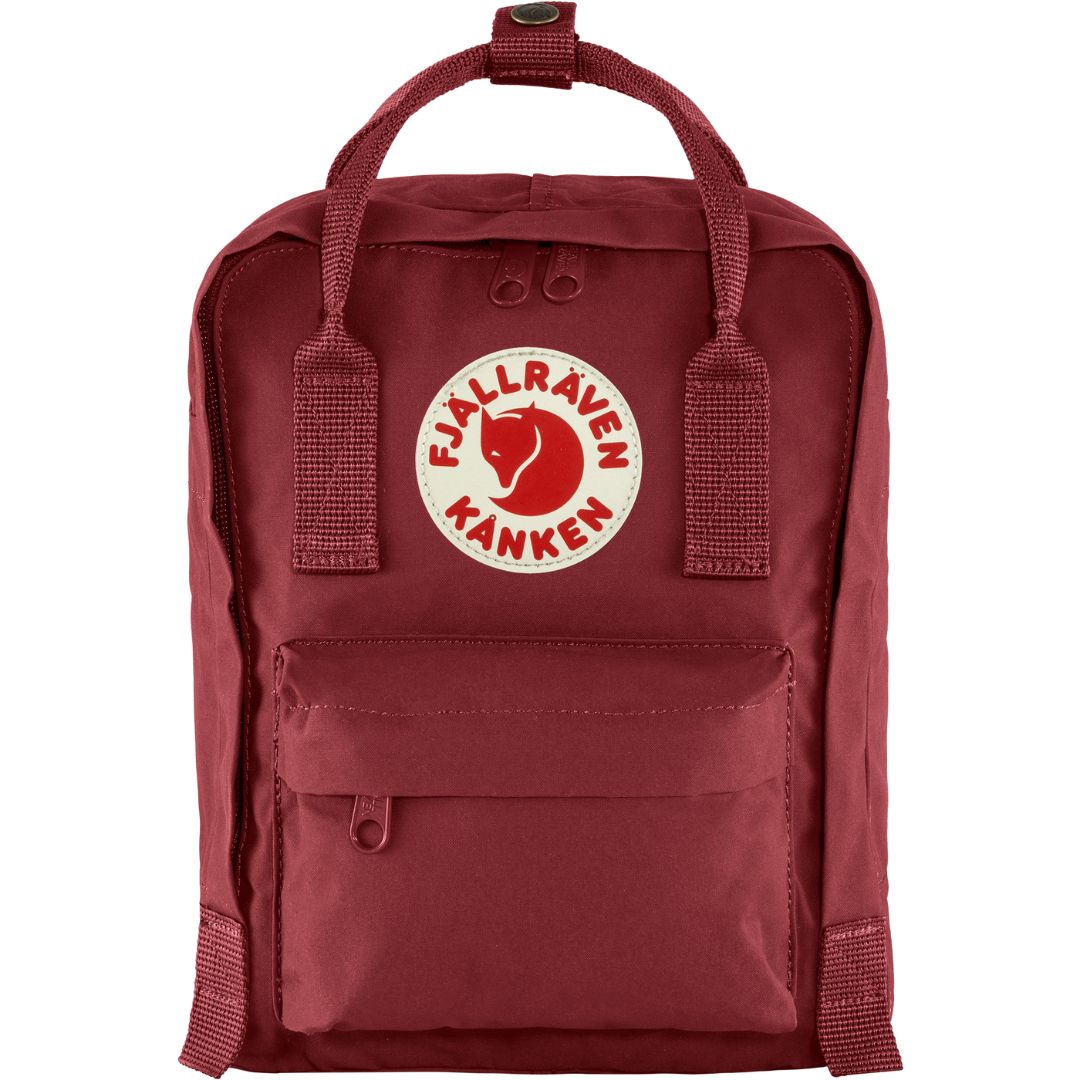 Vista frontal de la mochila Fjällräven Kånken Mini en color Ox Red, con logo reflectante y bolsillo exterior con cremallera