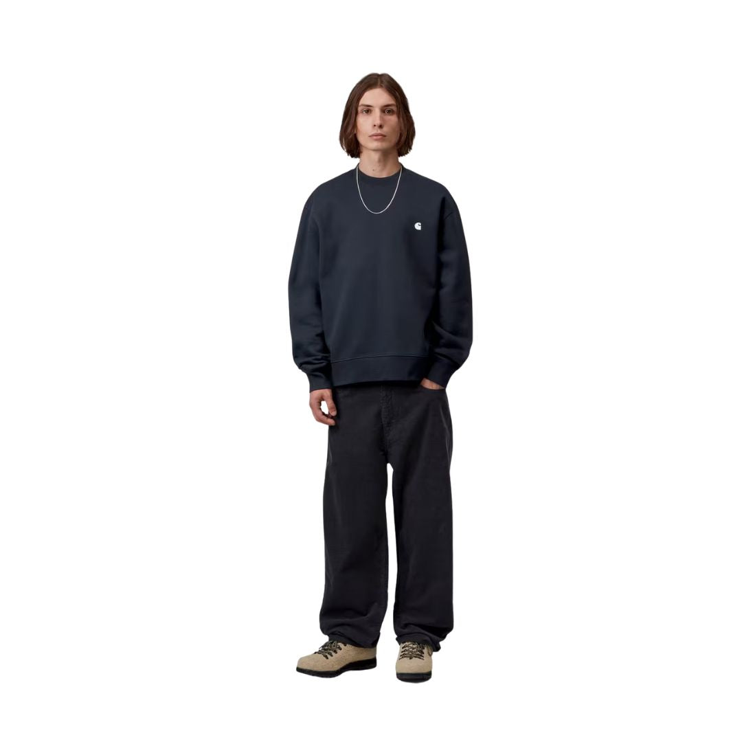 Carhartt WIP Mack Sweatshirt Dark Navy combinada en look completo con pantalón vaquero oscuro, mostrando el volumen del corte balloon y los hombros caídos.