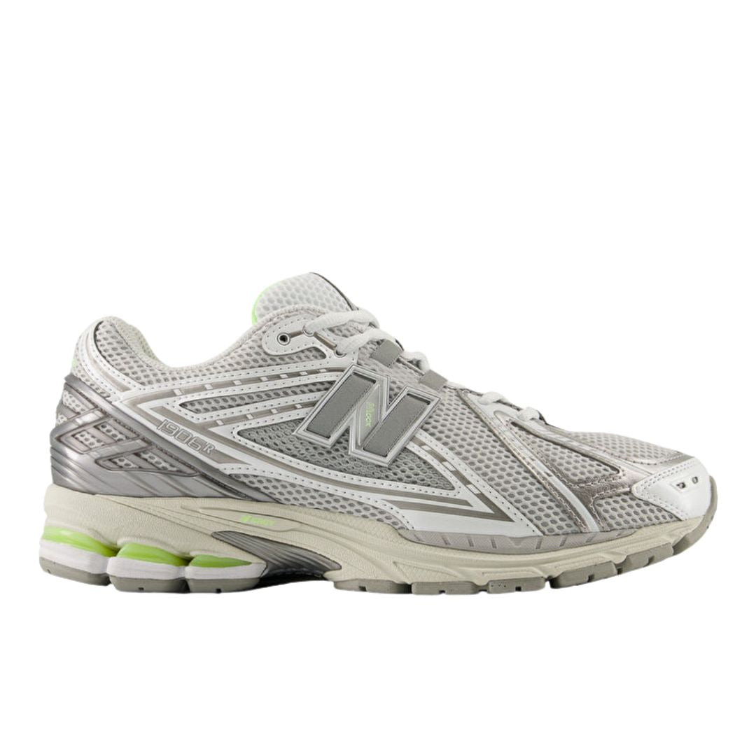New Balance 1906R Grey Matter, vista lateral exterior, upper de malla gris con overlays plateados, logo N plateado y detalles en verde lima en suela.
