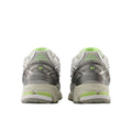 Vista trasera del par New Balance 1906R Grey Matter, contrafuerte gris con logo NB verde lima, talón con cápsula de amortiguación verde y suela crema.