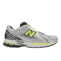Zapatilla New Balance 1906R retro running en gris plateado con detalles metallic y verde lima, logo N lateral, cordones blancos y mediasuela con tecnología ABZORB y N-ergy.