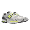 Zapatillas New Balance 1906R gris plateado y verde lima con upper de malla transpirable, logo N lateral en verde, cordones blancos y suela técnica segmentada con amortiguación.