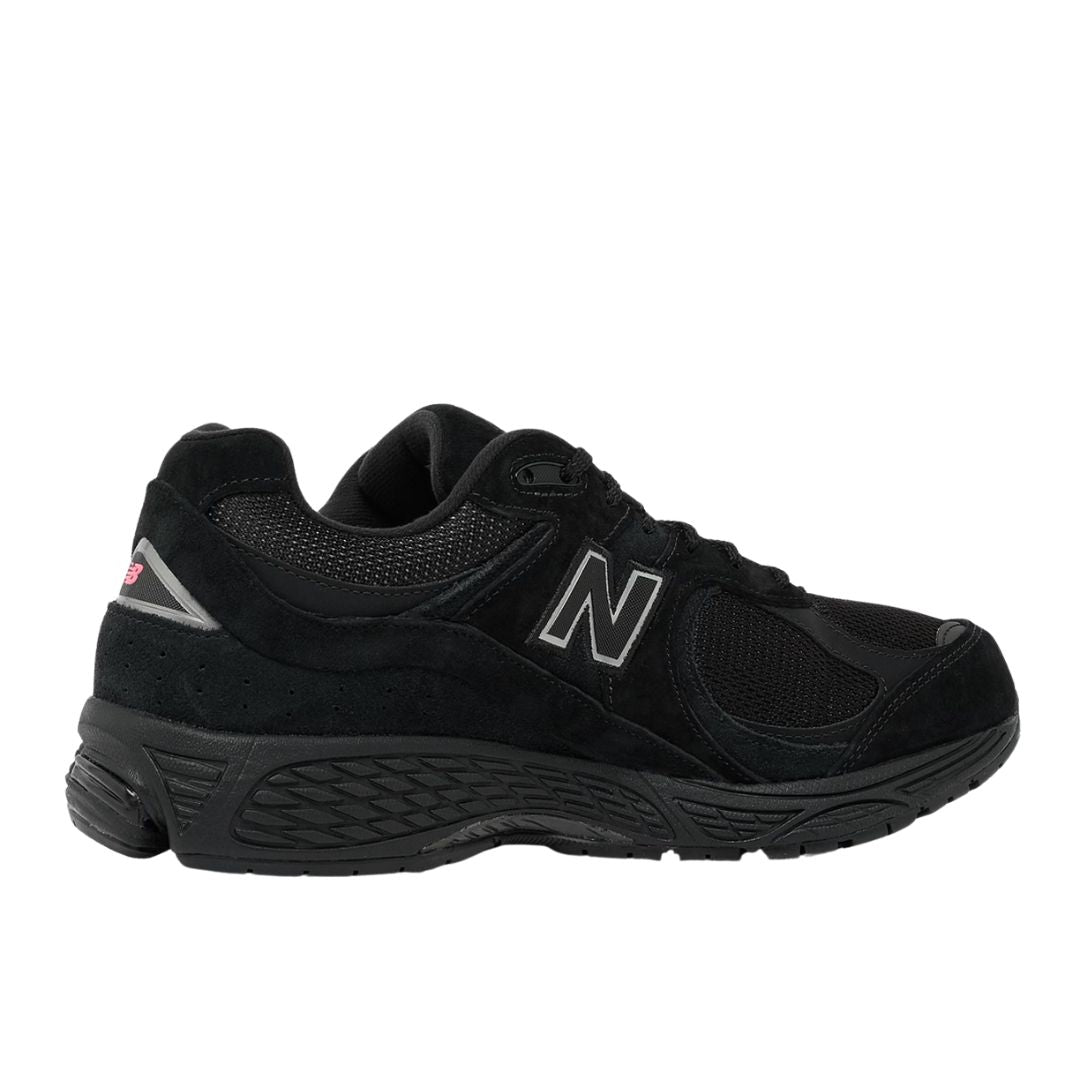 Vista lateral interior de las zapatillas New Balance 2002R color negro con detalles reflectantes.
