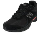 Primer plano frontal lateral de las zapatillas New Balance 2002R color negro con malla transpirable y cordones negros.