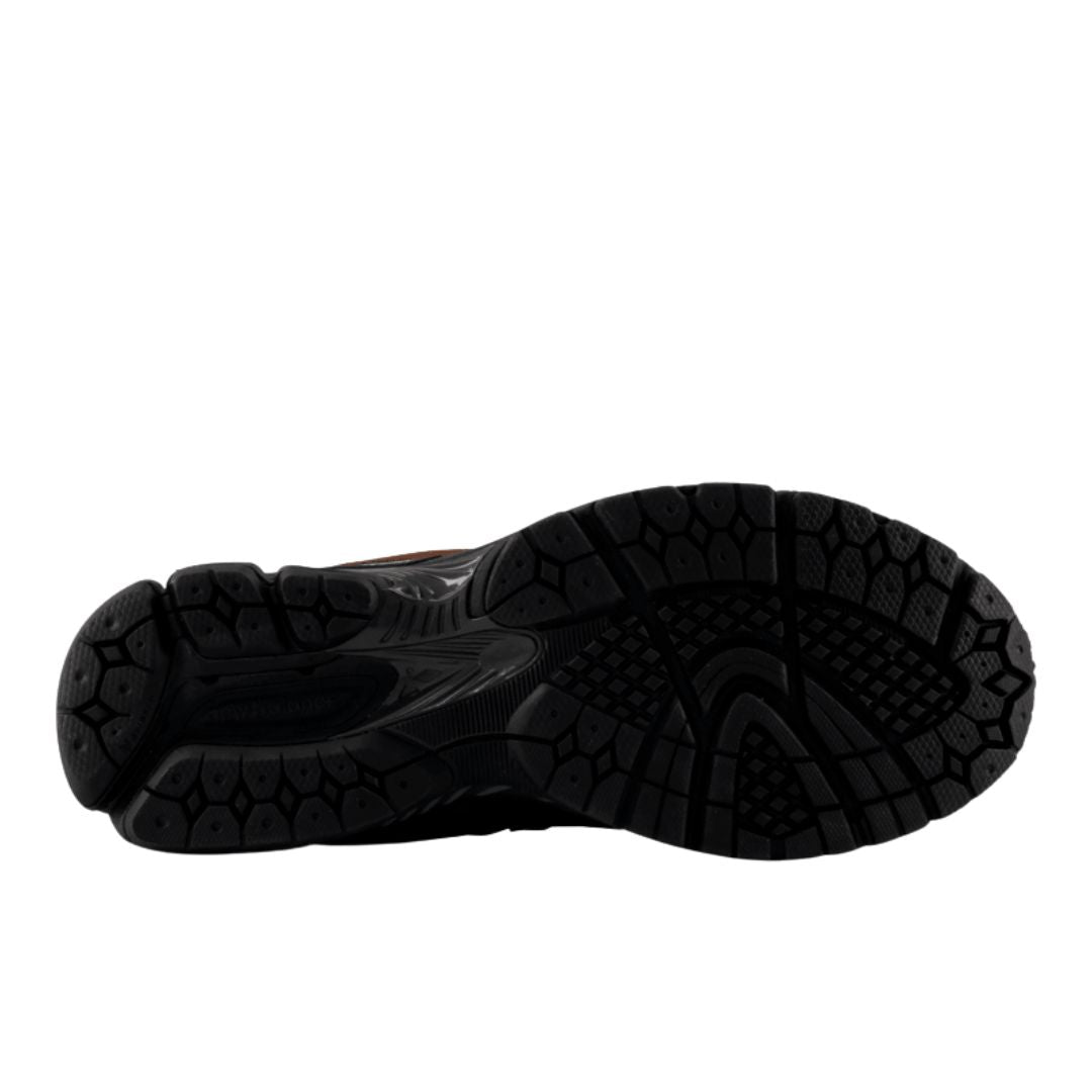 Suela de las zapatillas running retro New Balance 2002R pumpernickel, vista inferior de la goma negra con dibujo de celdas hexagonales y tacos para un agarre firme.