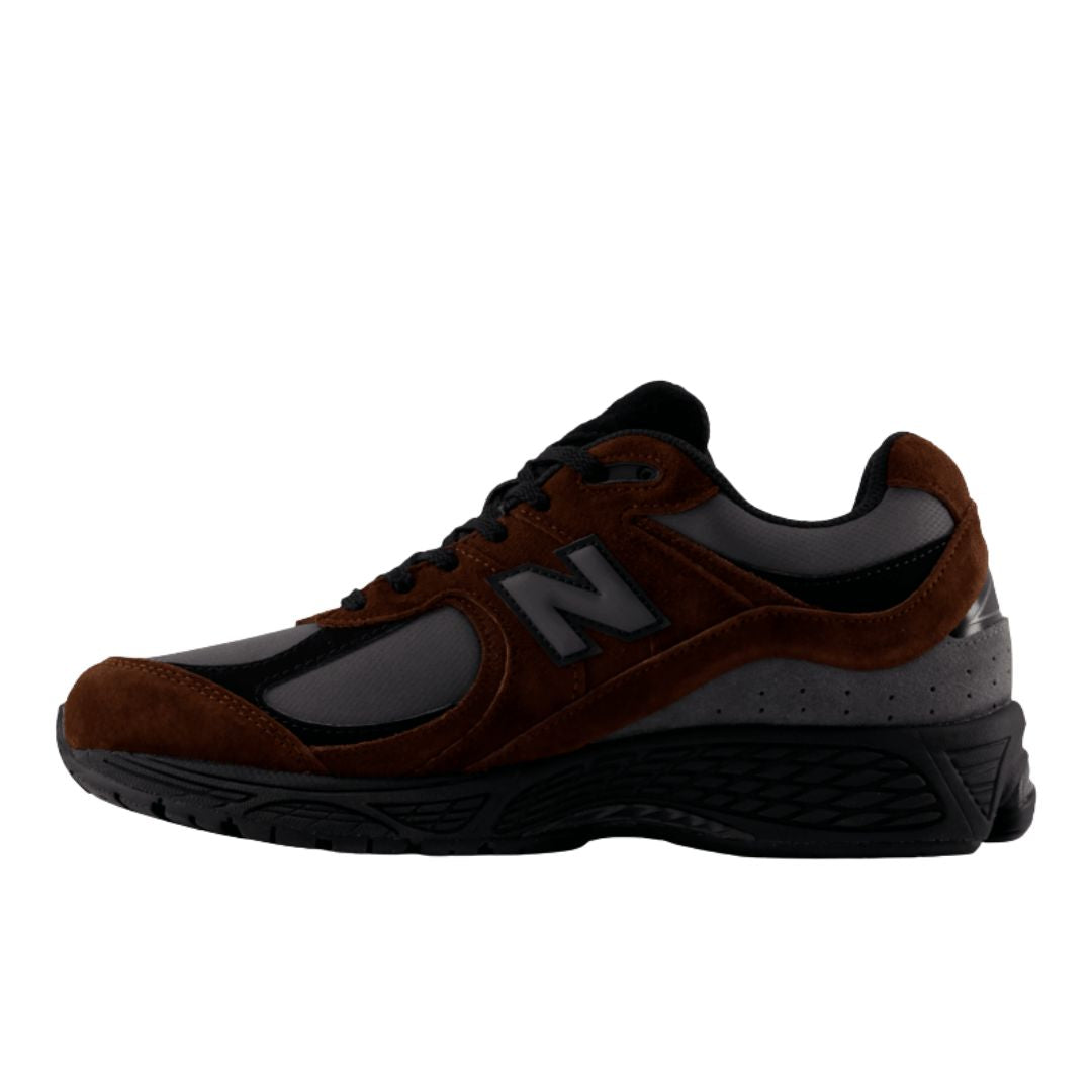 Zapatillas running retro New Balance 2002R pumpernickel, vista lateral interior con logo N en ante y paneles de malla gris sobre suela negra de gran amortiguación.