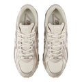 Vista cenital del par New Balance 204L Timberwolf en beige claro: cordones, lengüeta con etiqueta New Balance Running, plantilla y overlays sintéticos brillantes.