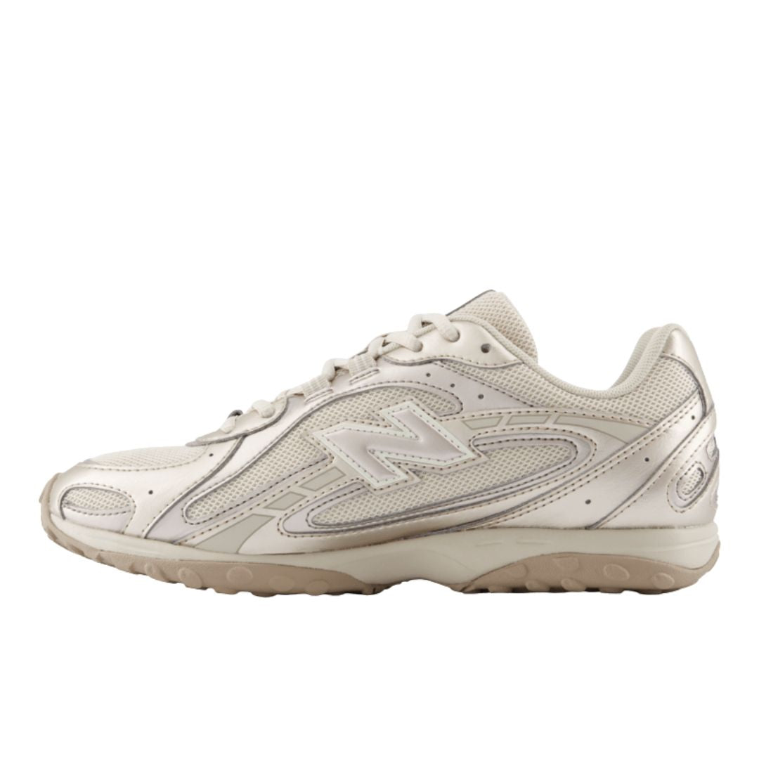 Zapatilla New Balance 204L Timberwolf unisex, vista lateral interna en beige claro con logo N moldeado, overlay en relieve y suela de perfil bajo con tacos.