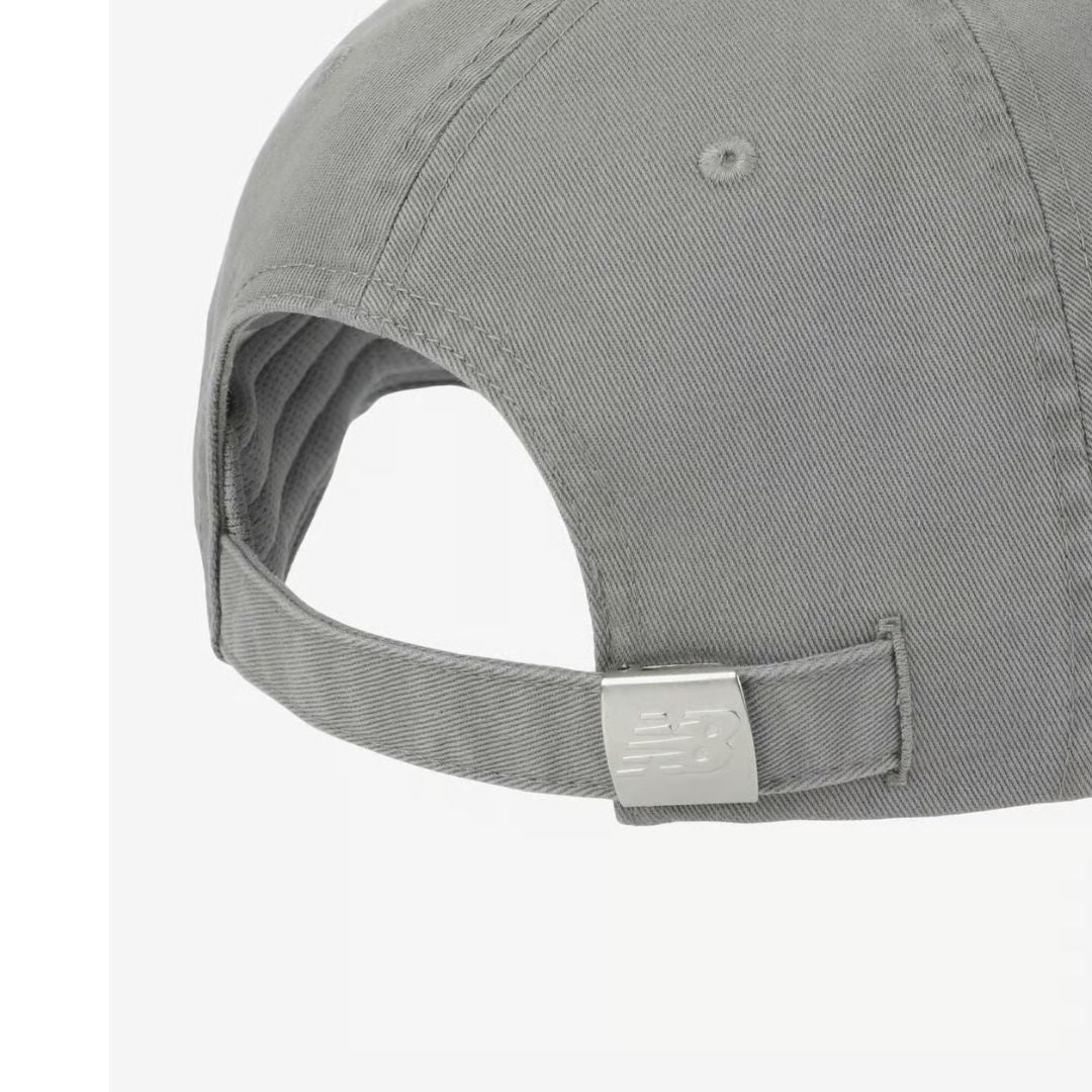 Detalle del cierre ajustable trasero de la gorra New Balance 6 Panel Classic Hat V 2.0 slate con correa de algodón gris y hebilla metálica plateada con logo NB grabado.