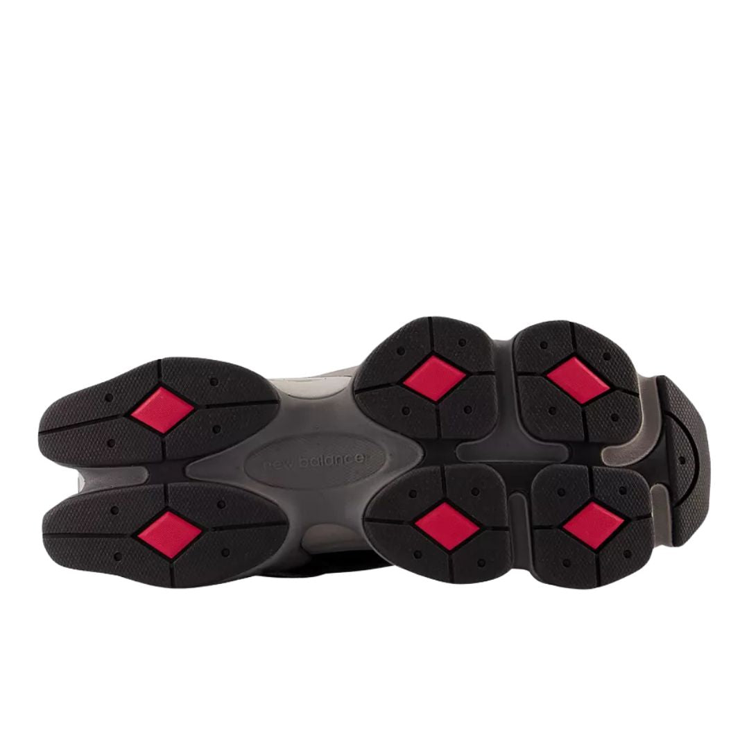 Suela de las New Balance 9060 Black Castlerock Rain Cloud con patrón de diamantes y detalles en rojo sobre base negra y gris.