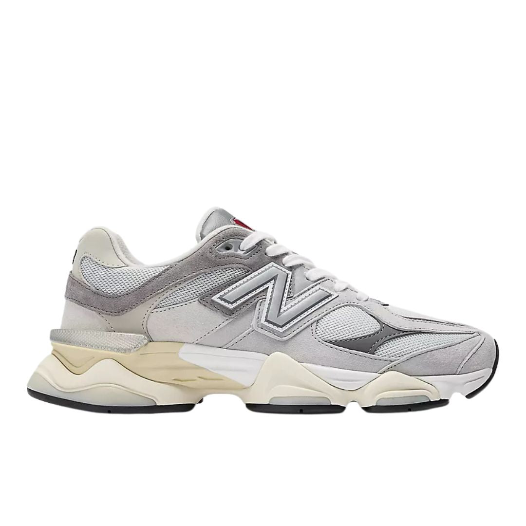 Perfil lateral izquierdo de las New Balance 9060 Rain Cloud Castlerock White con logo N plateado y entresuela sobredimensionada en tonos crema.