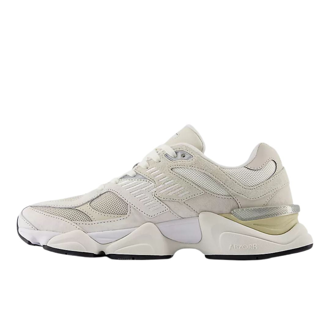 New Balance 9060 Sea Salt Moonbeam Turtledove perfil lateral con logo N plateado, paneles de malla transpirable y mediasuela voluminosa de doble densidad.