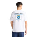 Vista trasera de la camiseta gráfica New Balance Fish and Chips blanca en modelo, con gran estampado Fish and Chips Flimby en azul, amarillo y negro.