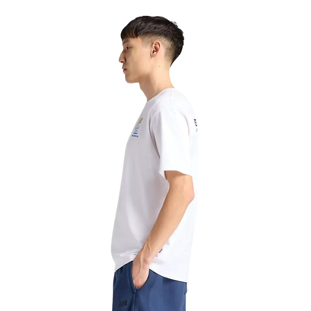 Camiseta gráfica New Balance Fish and Chips blanca, vista lateral izquierda en modelo, mostrando estampado trasero y corte holgado de manga corta.