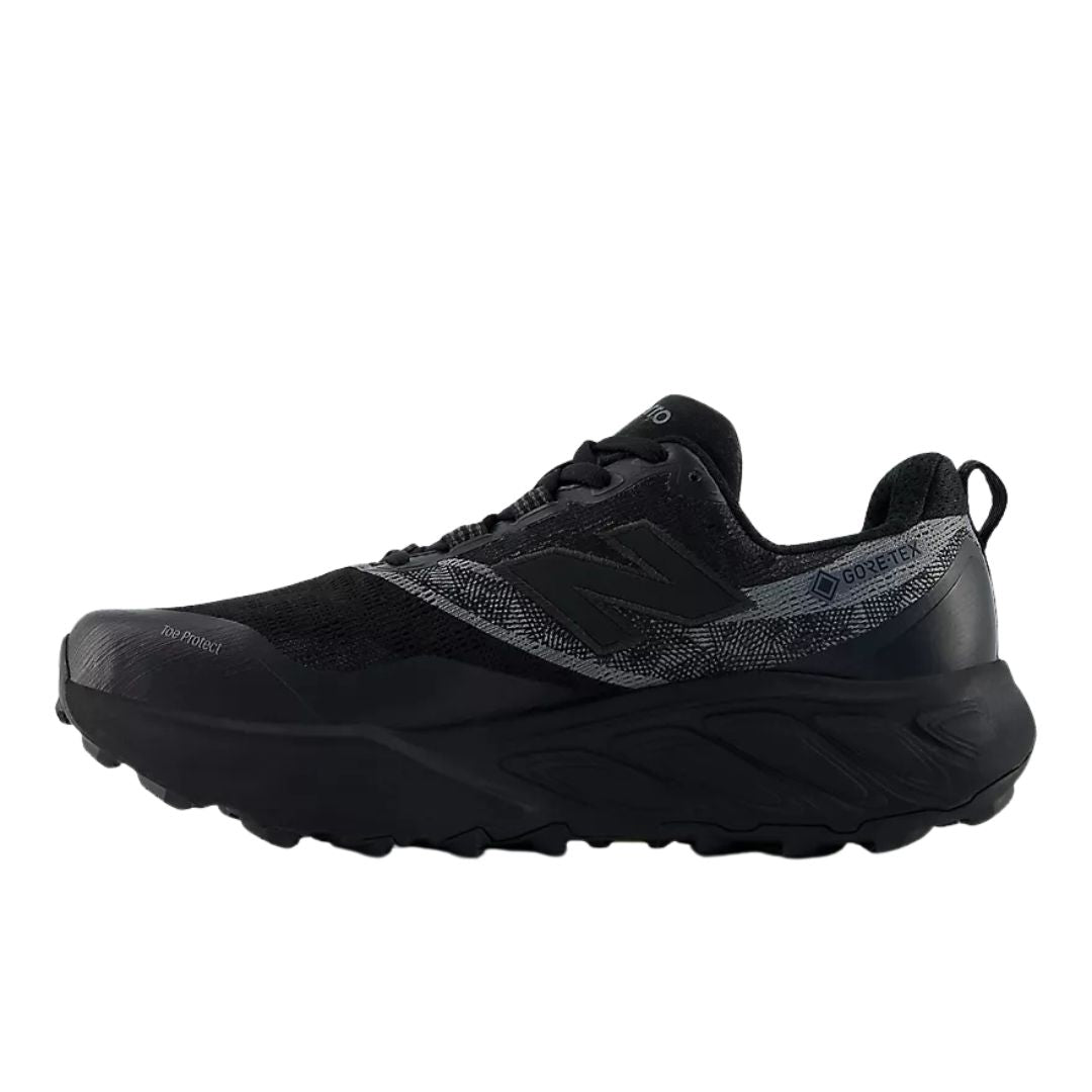 New Balance Hierro v9 GORE-TEX® en negro con Faded Black y Castlerock, perfil lateral con el logo N, la etiqueta GORE-TEX® y el refuerzo Toe Protect visible en la puntera.
