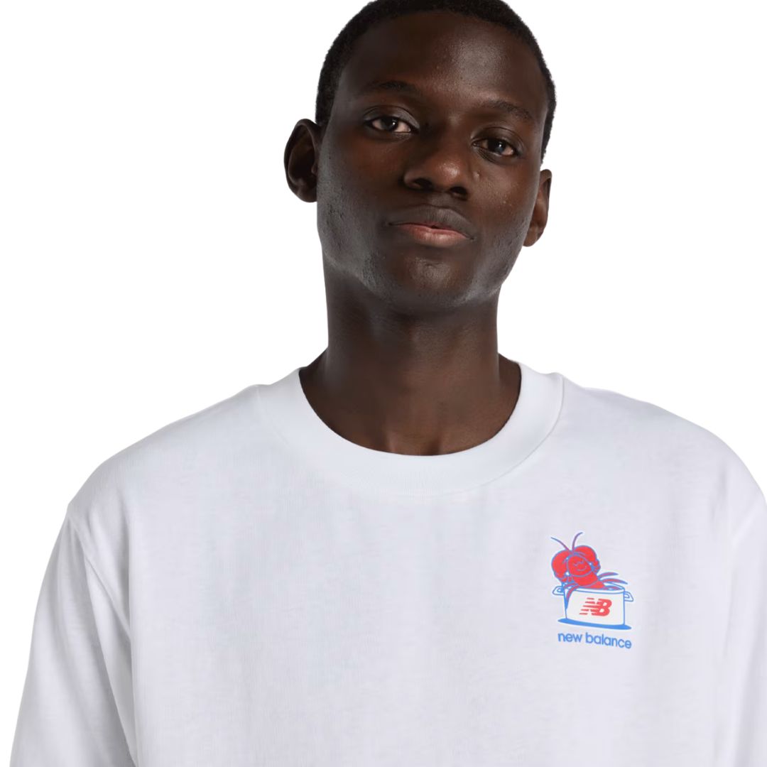 Primer plano estampado de pecho camiseta New Balance Lobster Roll blanca: ilustración de langosta roja sobre olla con logo NB y texto new balance en azul.