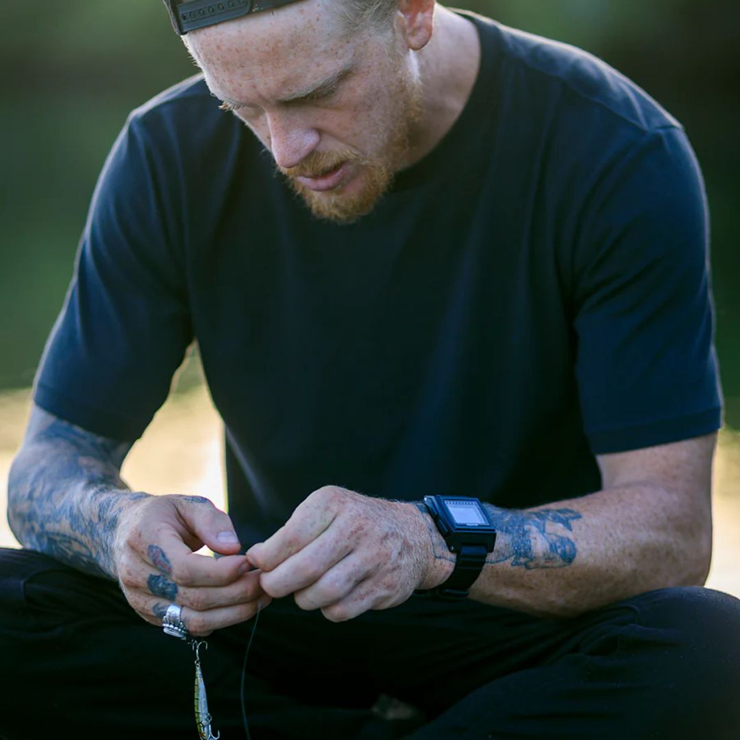 Persona usando el reloj Nixon Base Tide Pro durante actividad al aire libre.