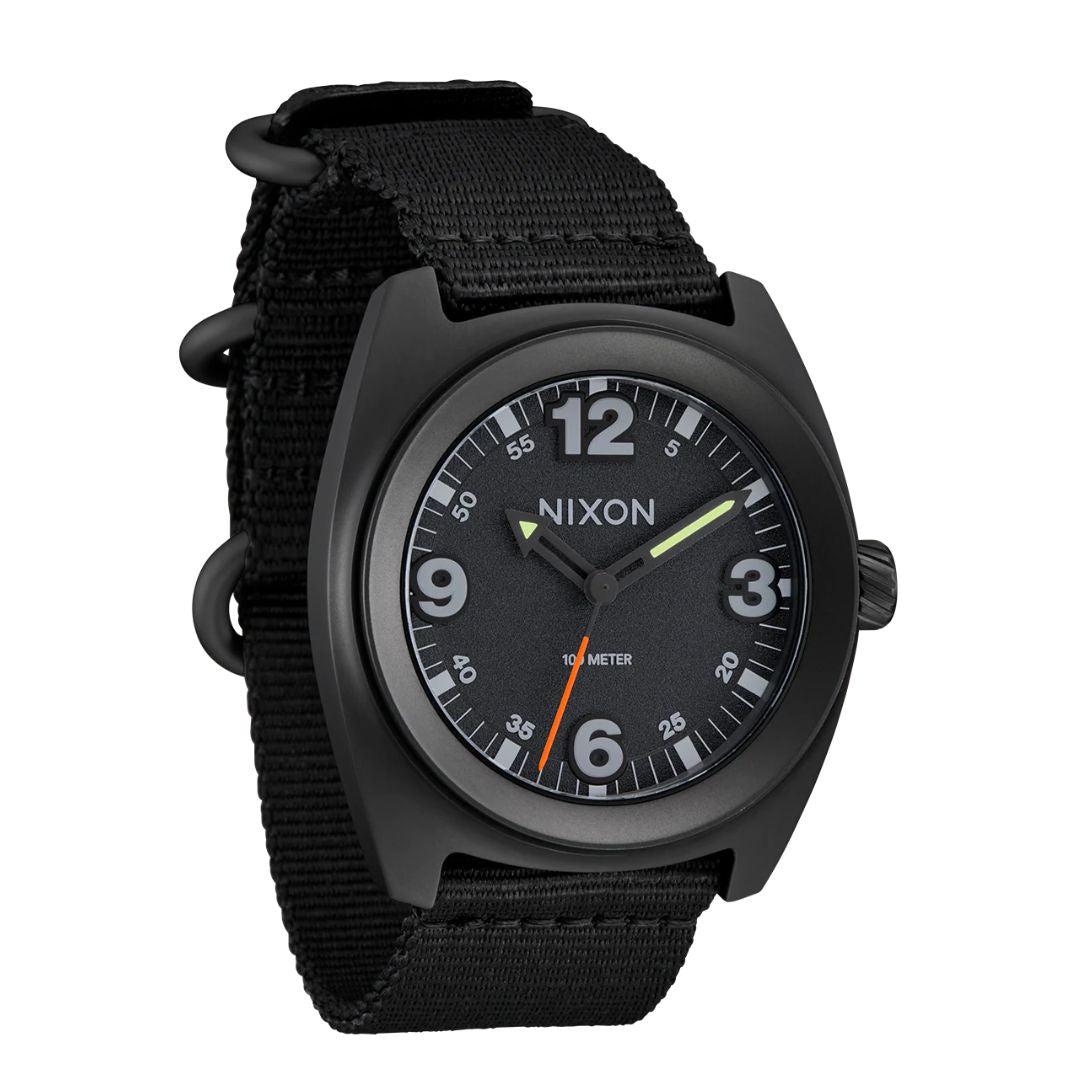 Vista frontal del reloj Nixon Clutch 42 All Black mostrando esfera negra con números luminiscentes y manecillas LUME.