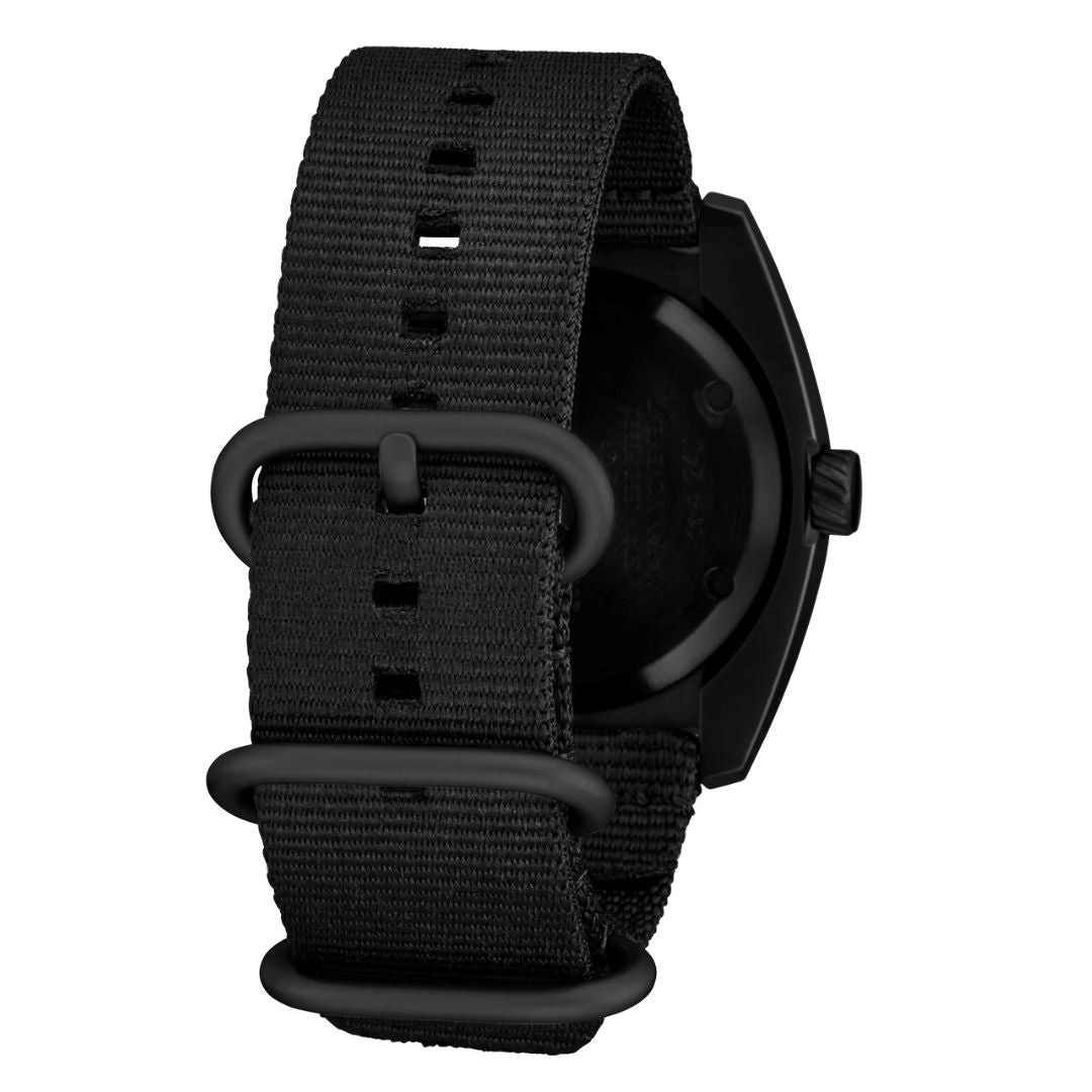 Detalle de la correa de nailon negra del reloj Nixon Clutch 42 All Black con hebillas metálicas mate.