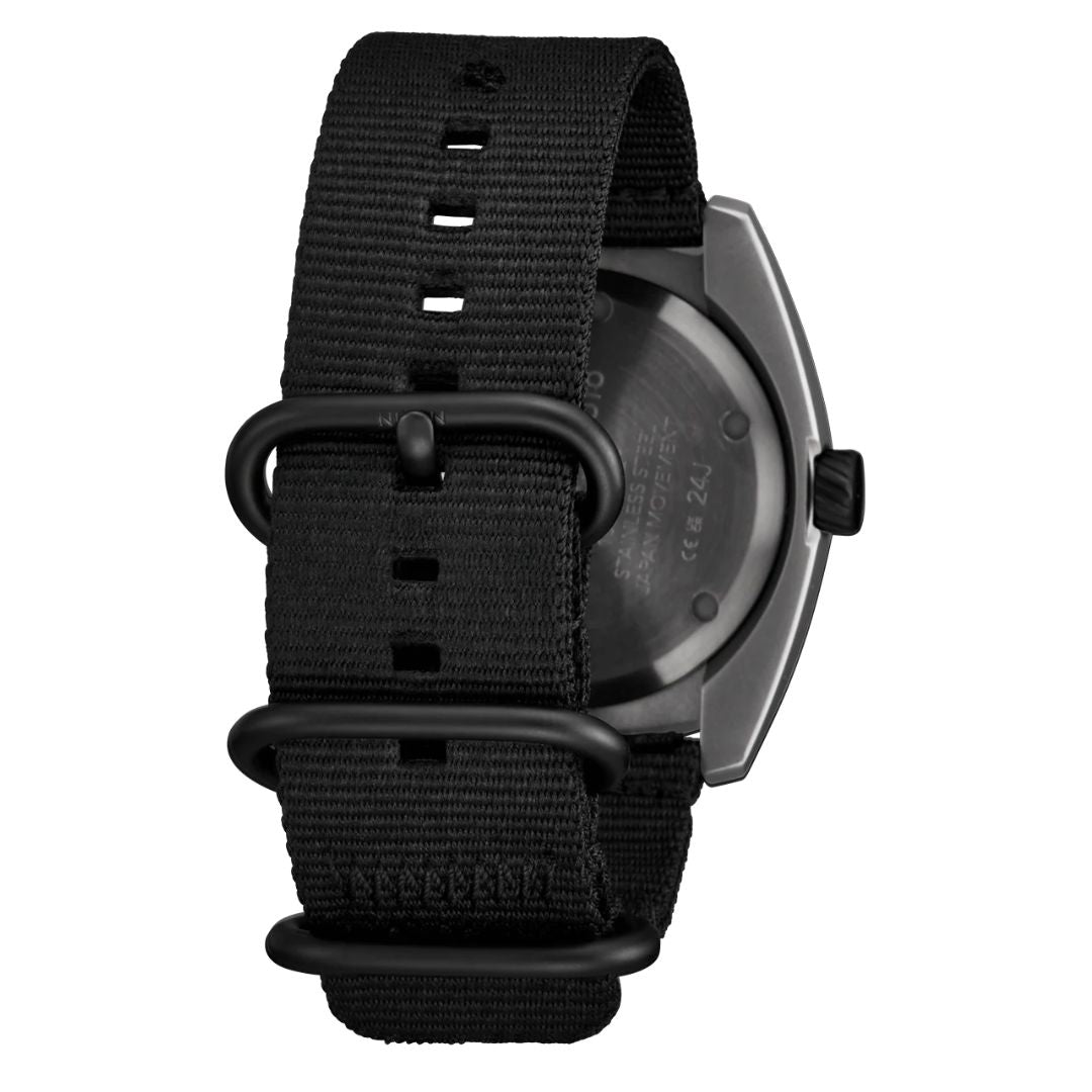 Detalle de la correa de nailon negro del reloj Nixon Clutch 42 Matte Gunmetal Hot Sauce con hebillas metálicas.