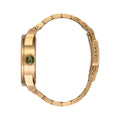 Vista lateral del reloj Nixon Sentry Stainless Steel dorado con corona verde.