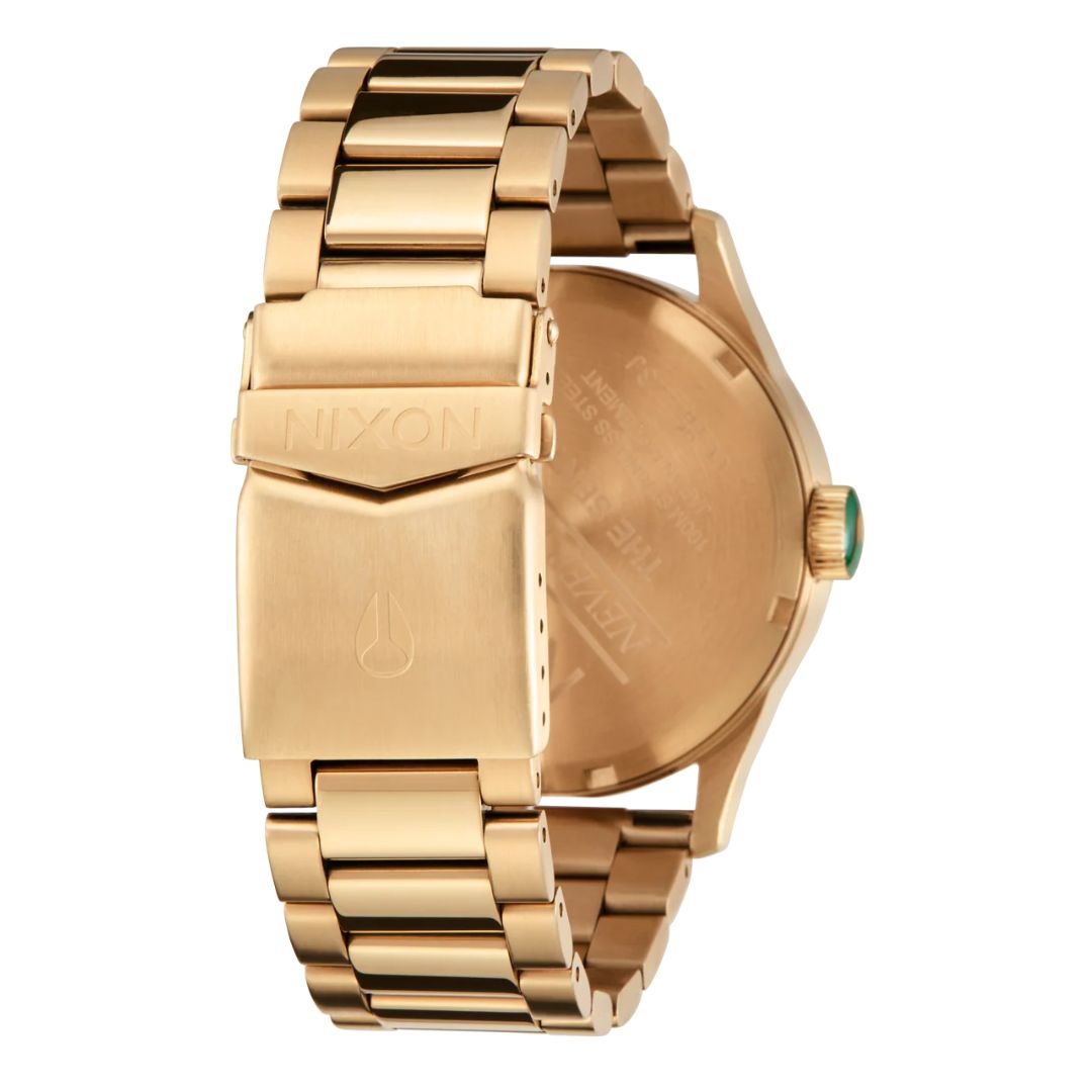 Cierre de la correa del reloj Nixon Sentry Stainless Steel dorado con logotipo Nixon grabado.