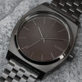 Primer plano del Nixon Time Teller All Black con esfera negra, índices plateados y diseño minimalista.
