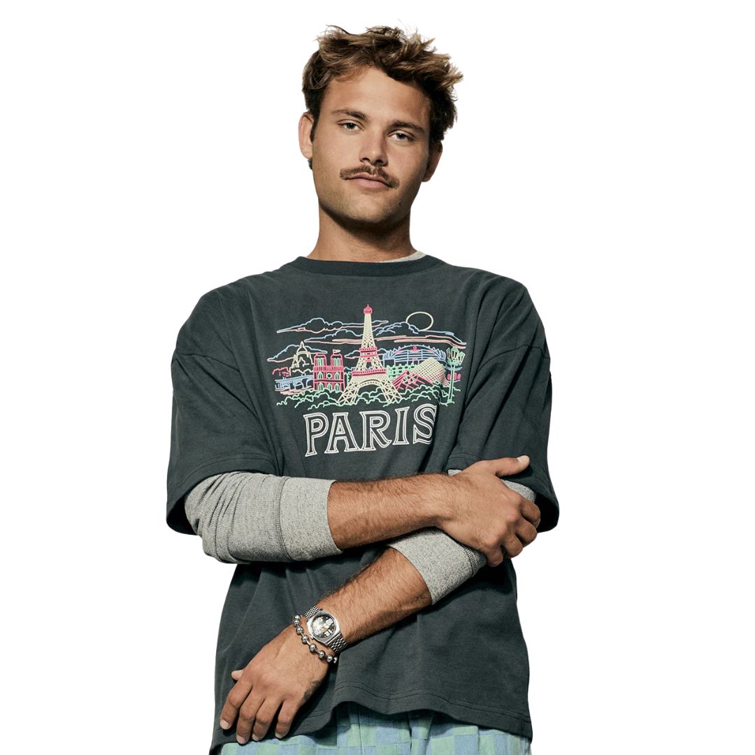 Hombre con reloj Nixon Time Teller Fisheye plateado y camiseta con estampado de París