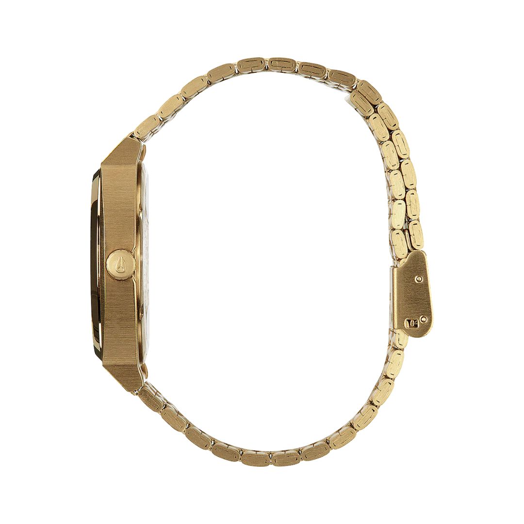 Vista lateral del reloj Nixon Time Teller dorado con esfera rojo oxblood sunray y correa metálica.