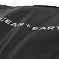 Detalle logo Ocean & Earth sobre tejido técnico negro ripstop de la funda COR_X Fish Day Cover.