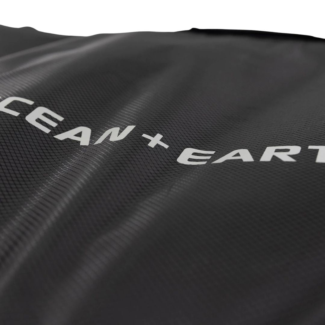 Detalle logo Ocean & Earth sobre tejido técnico negro ripstop de la funda COR_X Fish Day Cover.
